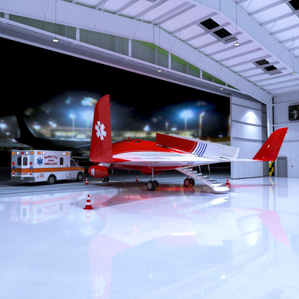 Red and white air ambulance in a hangar with an ambulance truck nearby; night setting.
