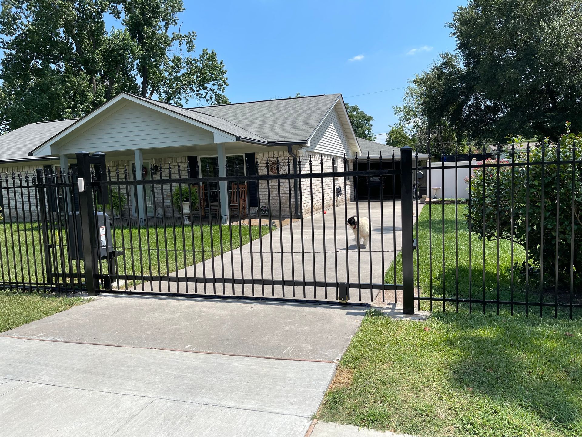 a houston surburb home with a gate at the driveway entrance