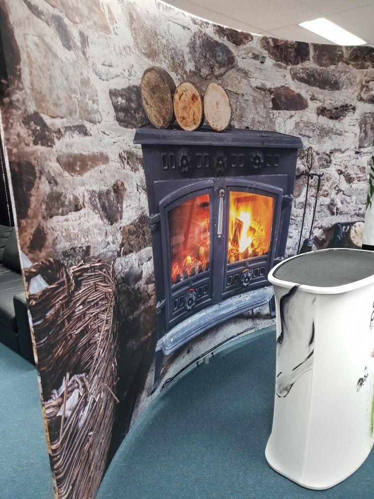 There is a picture of a fireplace on the wall behind a table.