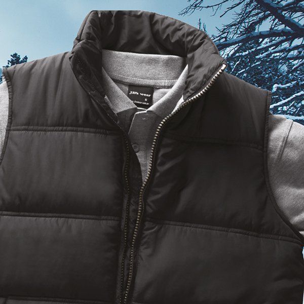 A person wearing a black vest and a grey shirt