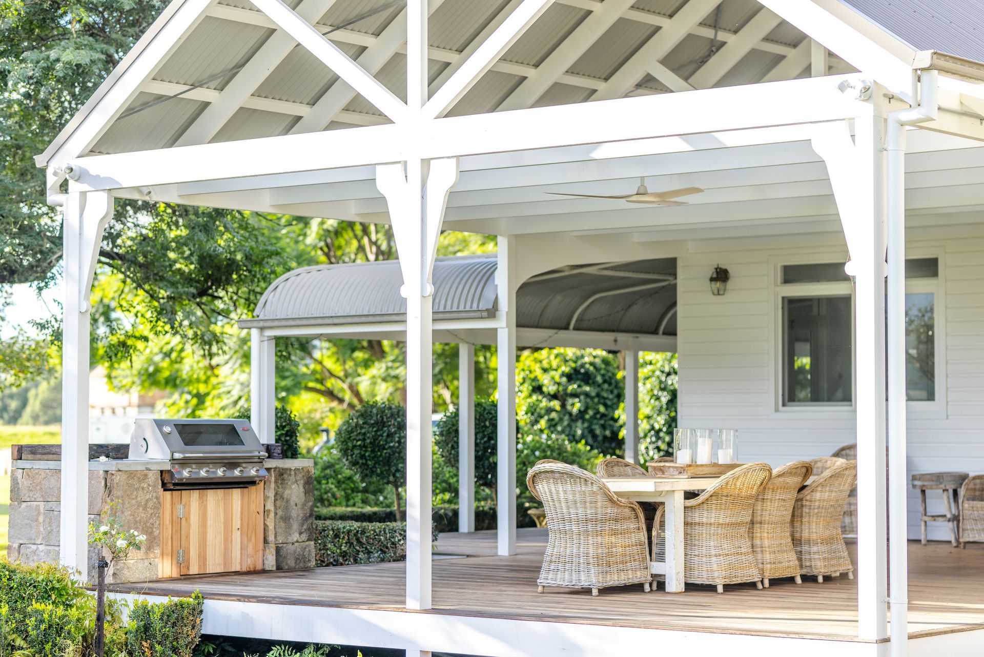 White-framed outdoor patio with table, chairs, and grill, with a green yard in the background — Stark Building & Constructions In Kiama, NSW