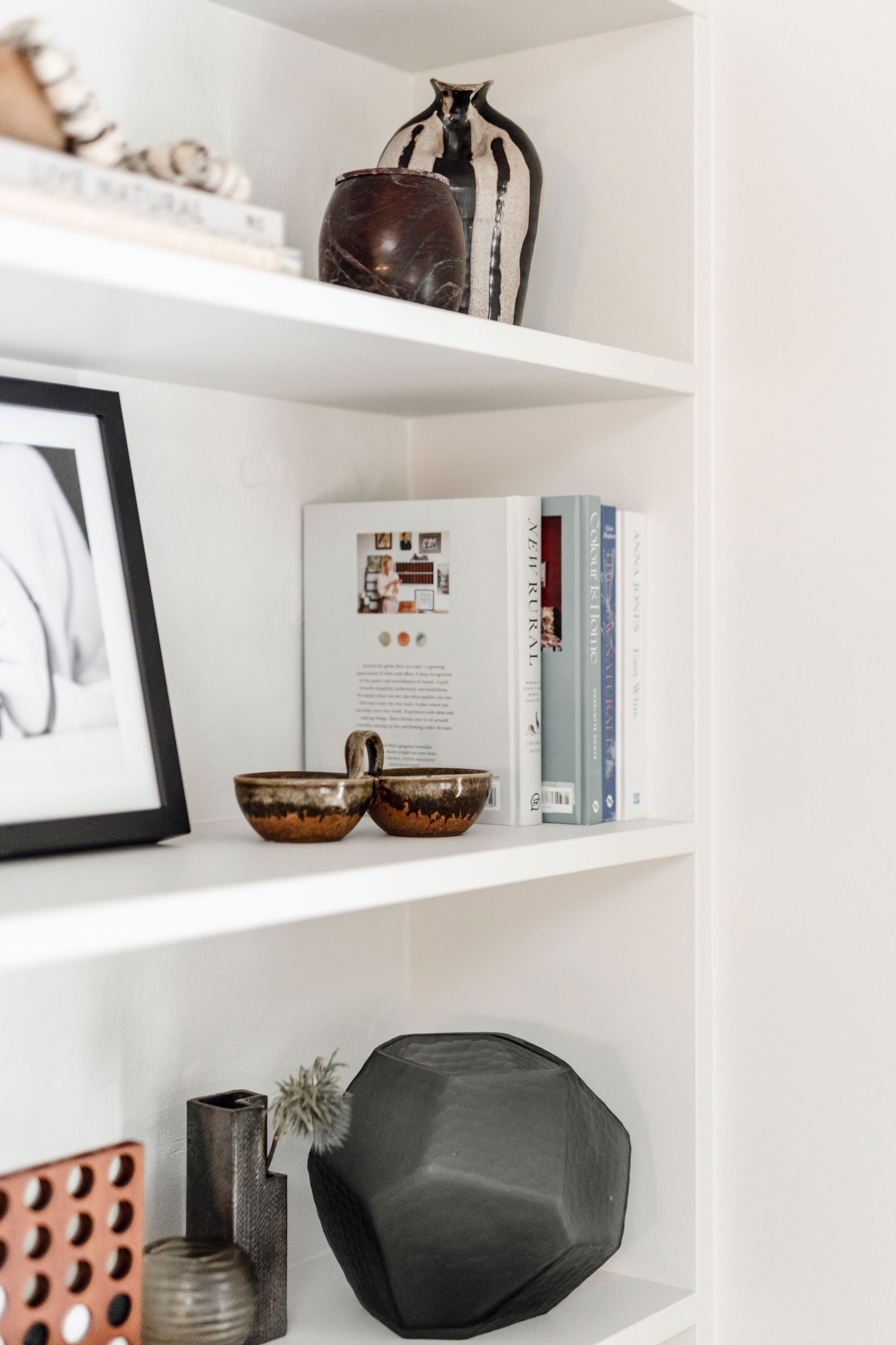 White shelves with decorative items: art, books, vases, and bowls  — Stark Building & Constructions In Shoalhaven, NSW