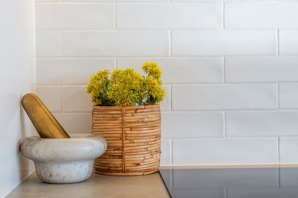 Mortar and Pestle Beside a Wicker Pot With Yellow Flowers — Stark Building & Constructions In Berry, NSW 
