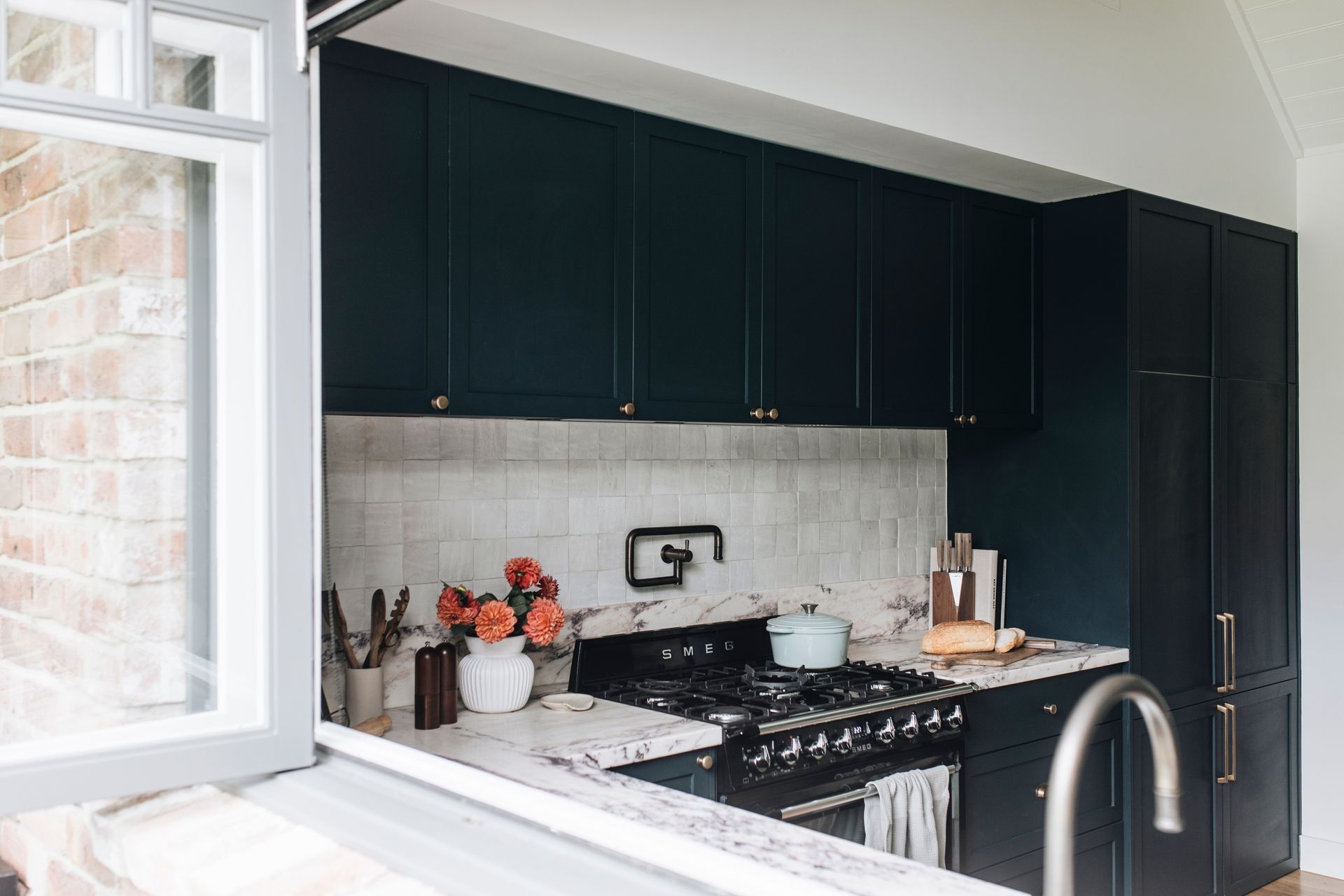 Kitchen with navy blue cabinets, white countertops, and a black stovetop — Stark Building & Constructions In Berry, NSW