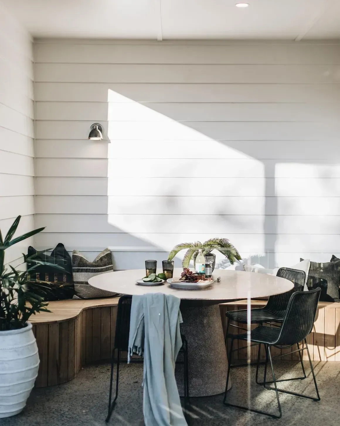 Sunlit Outdoor Dining Area With a Round Table, and Black Chairs — Stark Building & Constructions In Berry, NSW