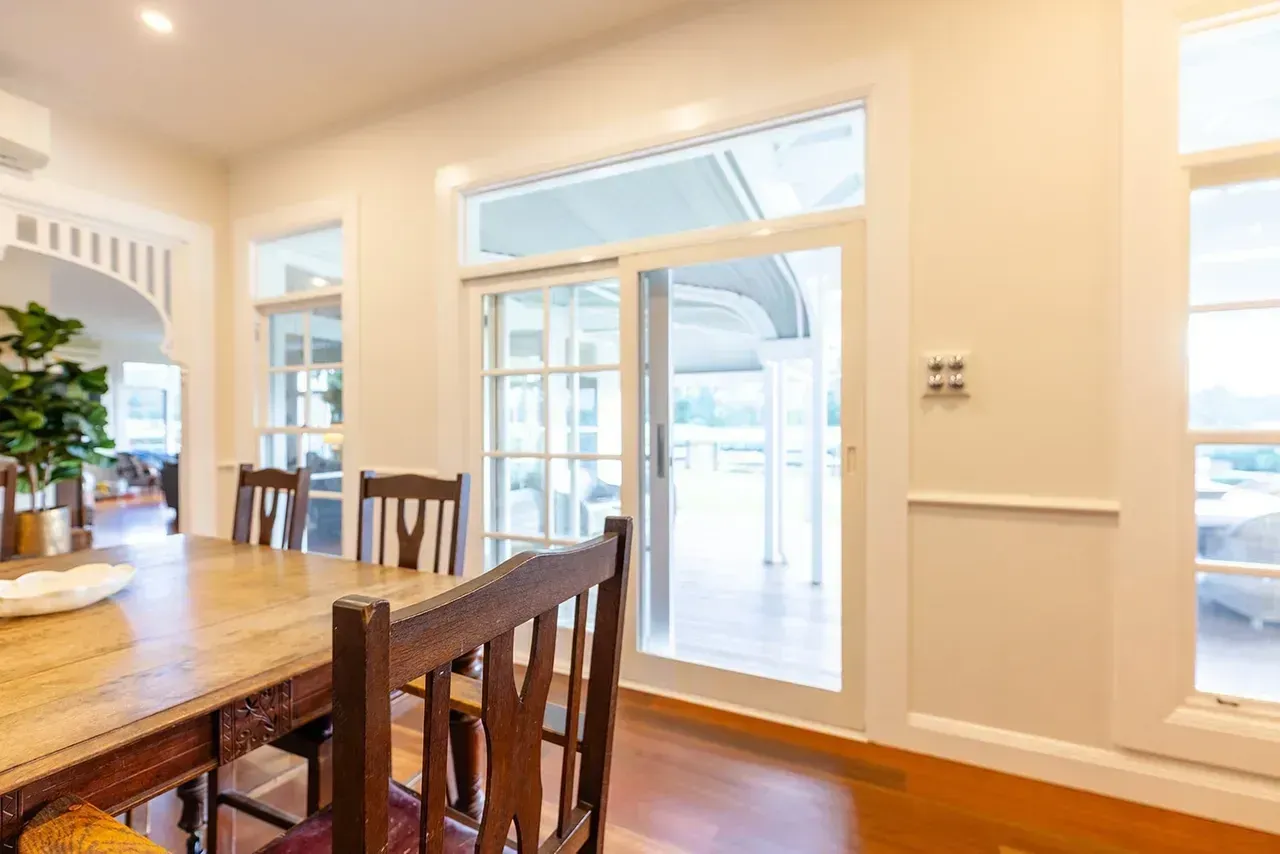 Dining Room With Wooden Table, Chairs, and Sliding Glass Door — Stark Building & Constructions In Berry, NSW
