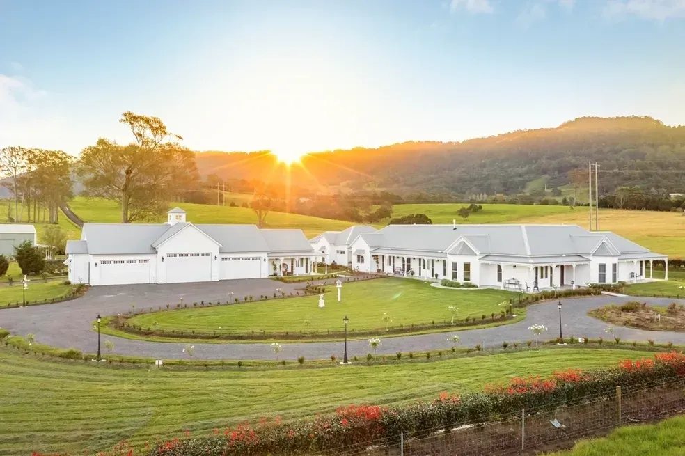 White Buildings on a Green Hill, With a Sunrise in the Background — Stark Building & Constructions In Berry, NSW