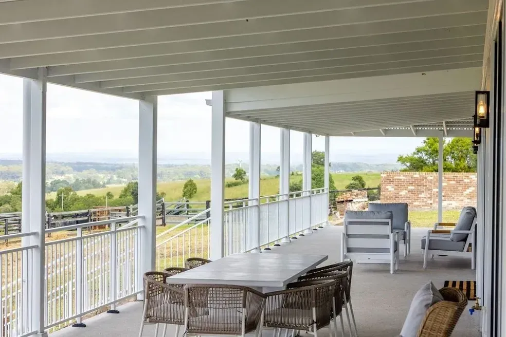 Covered Outdoor Patio With Table, Chairs, and a Scenic View of a Green Landscape — Stark Building & Constructions In Berry, NSW
