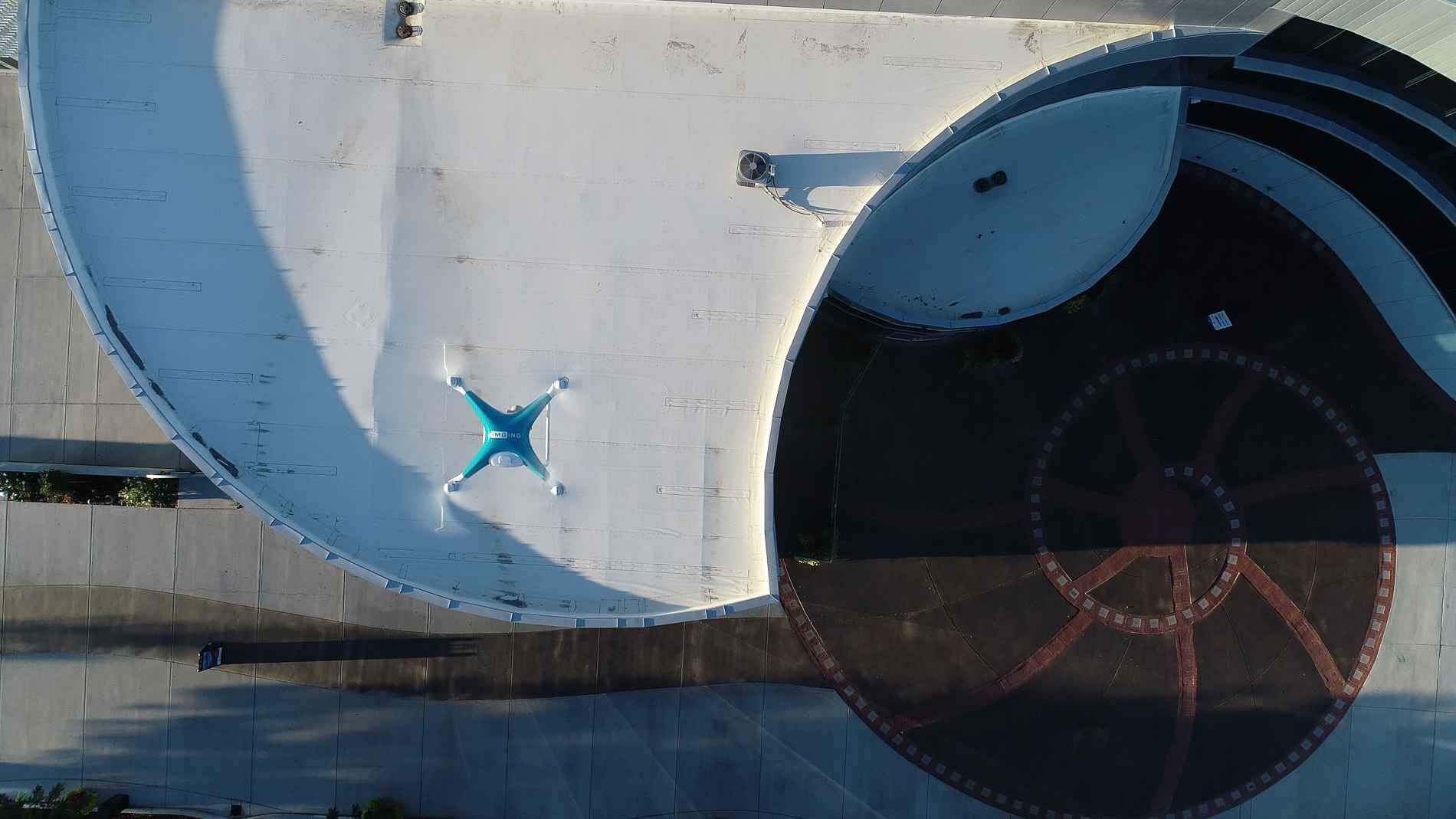 An aerial view of a drone flying over a building.