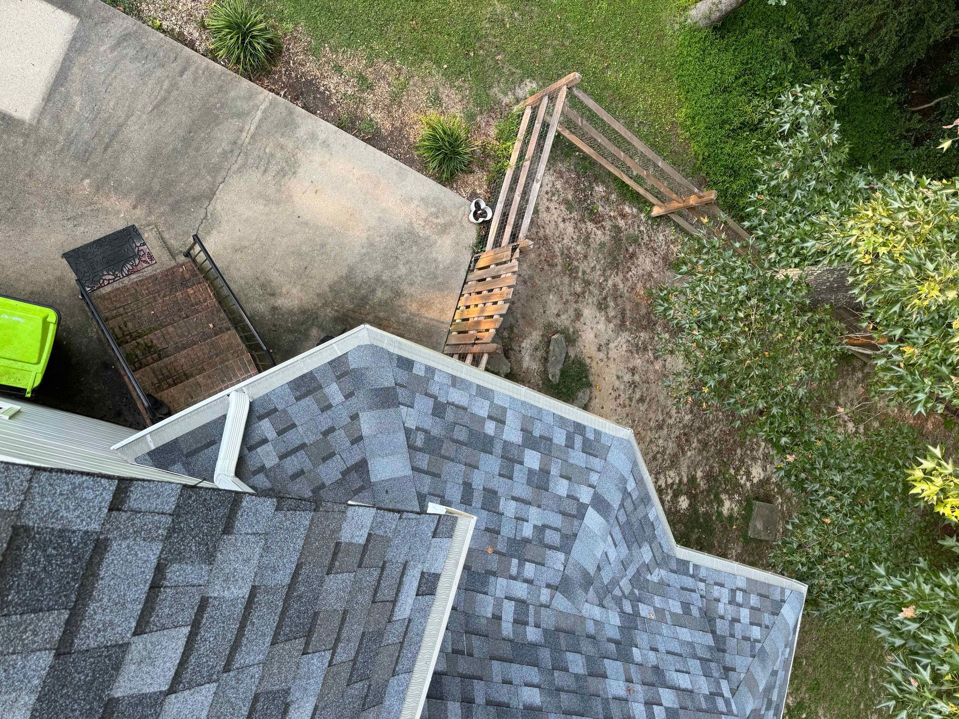 An aerial view of a roof with shingles being installed.