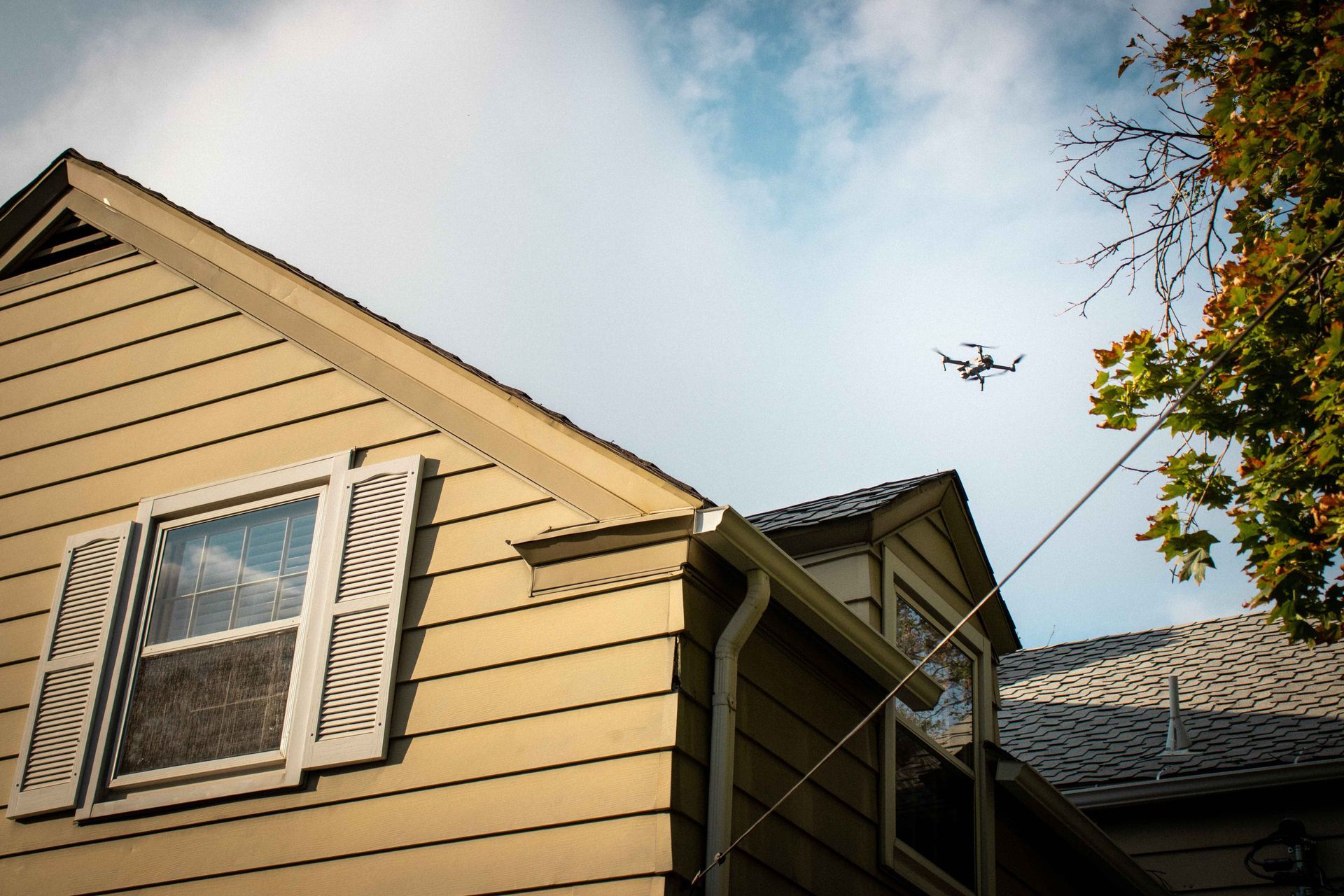 A drone is flying over a house on a sunny day