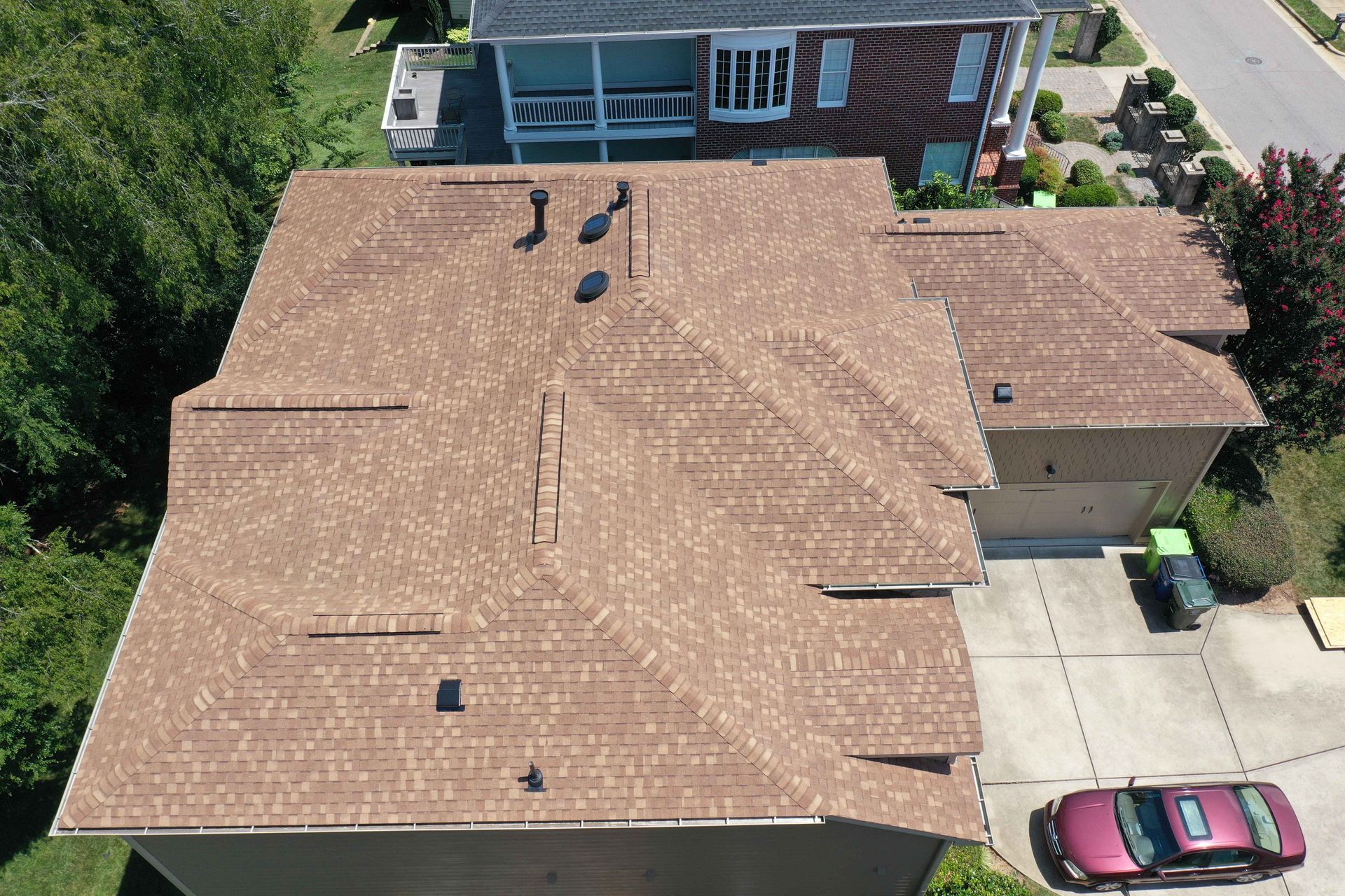An aerial view of a large house with a car parked in front of it.