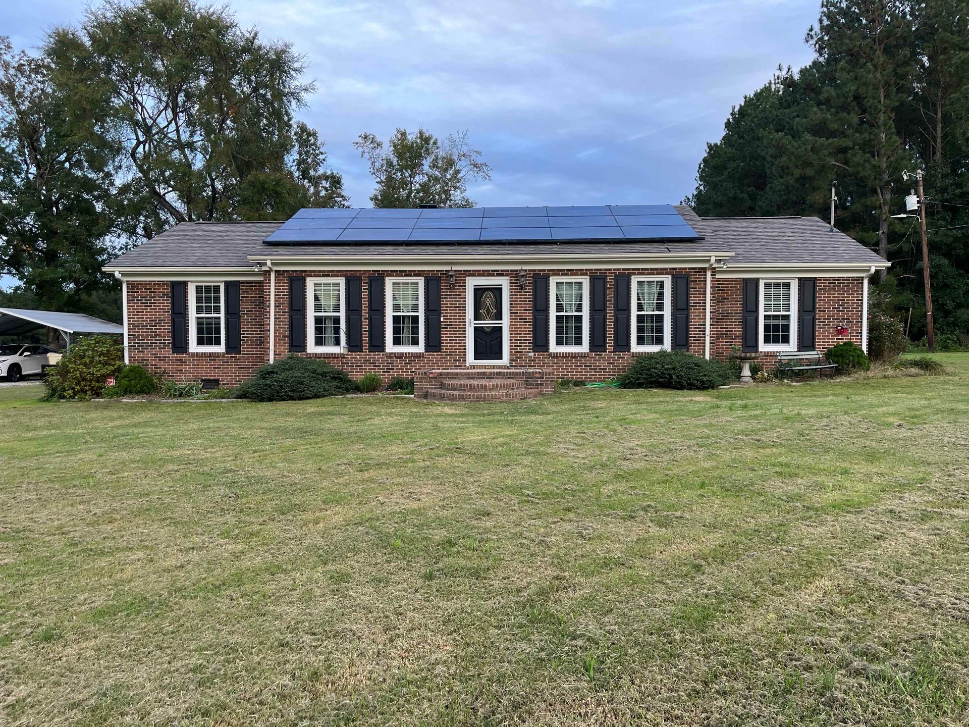 A large brick house with a solar panel on the roof.