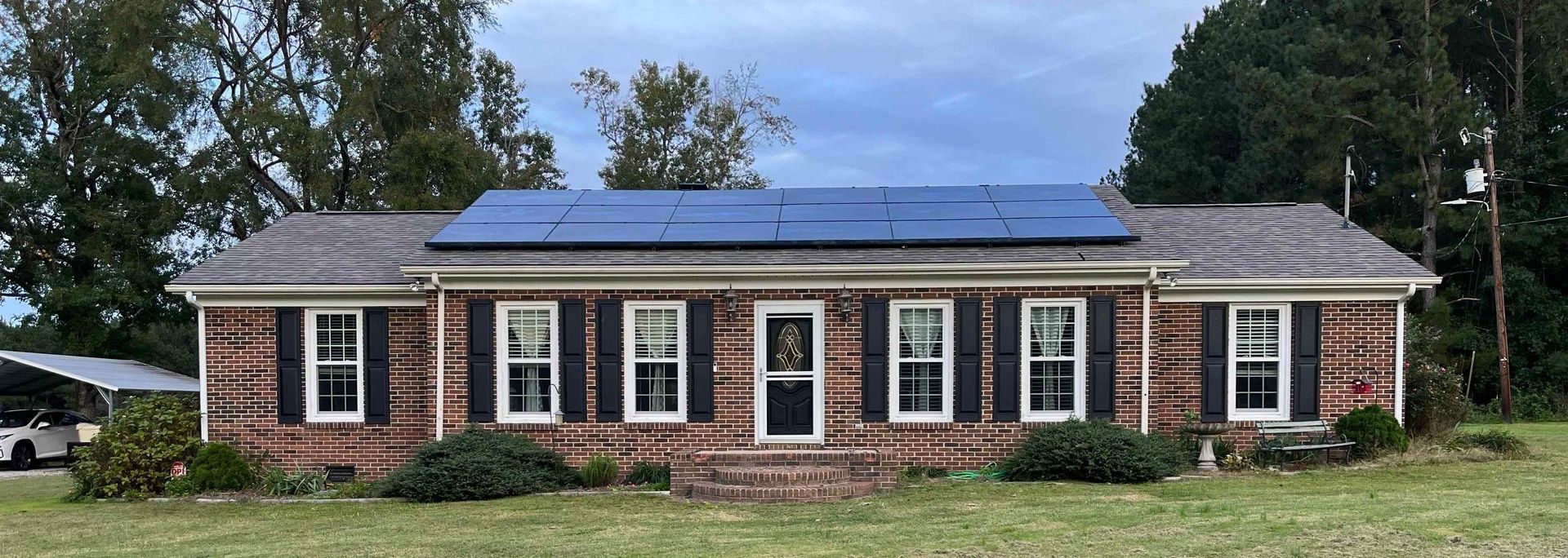 A brick house with solar panels on the roof.