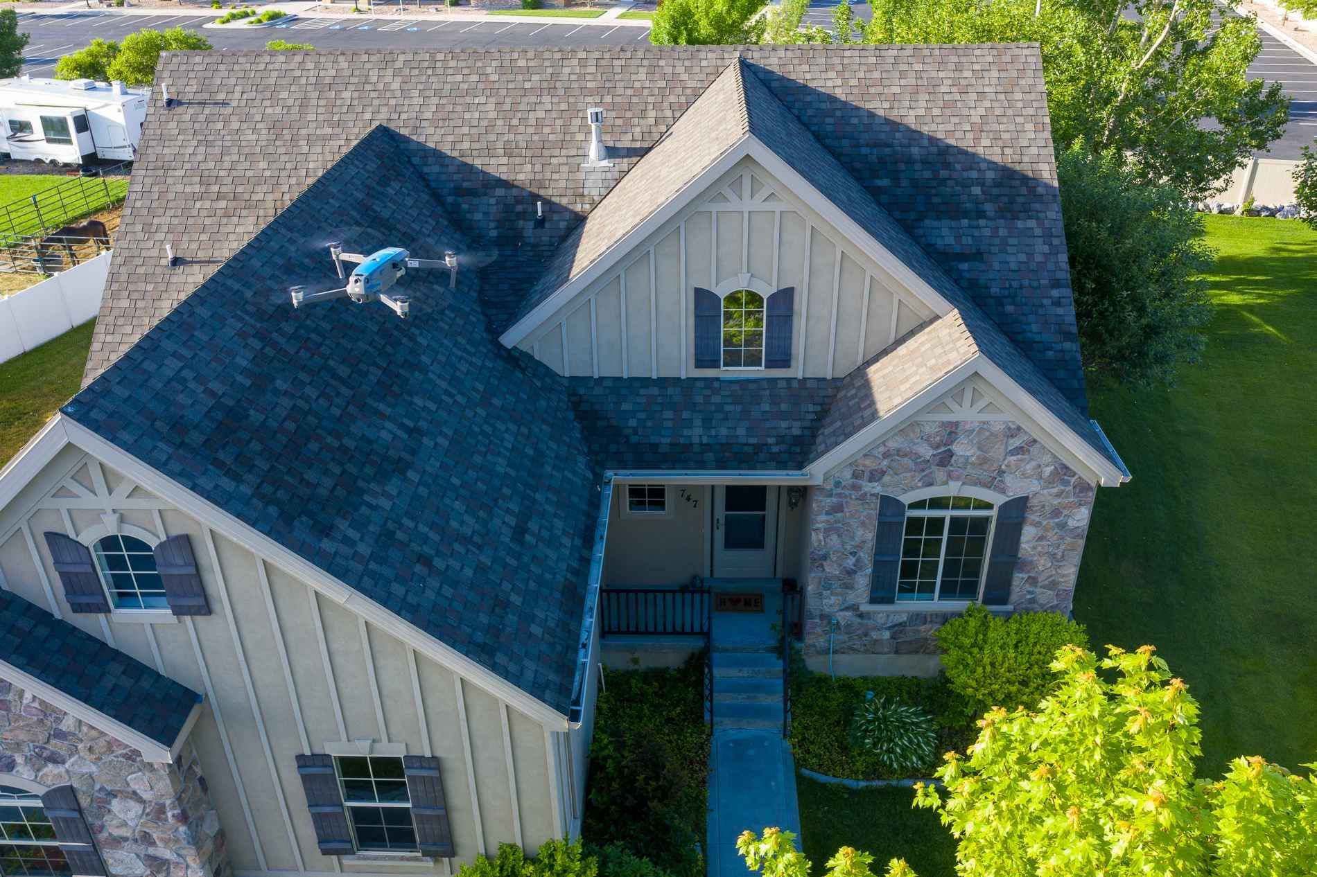 An aerial view of a house with a drone flying over it.