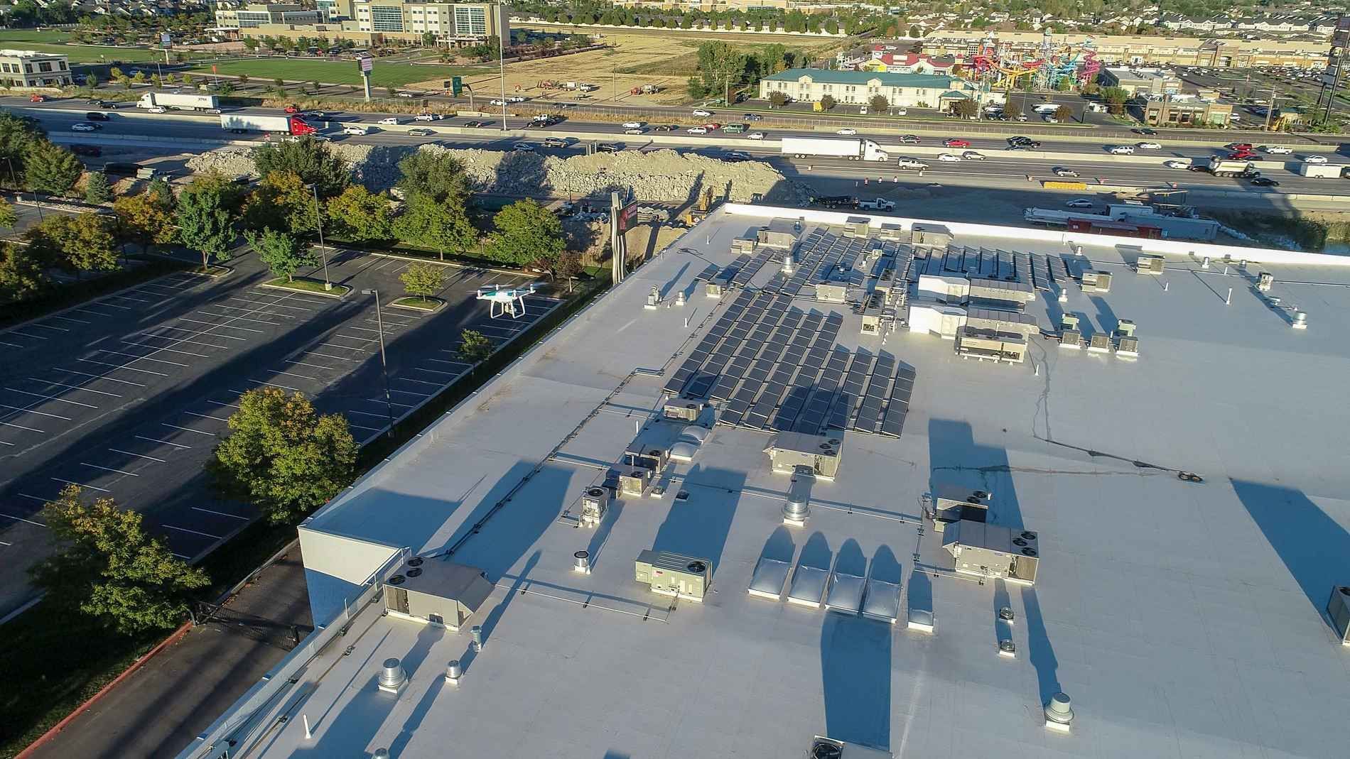 An aerial view of a large building with solar panels on the roof.