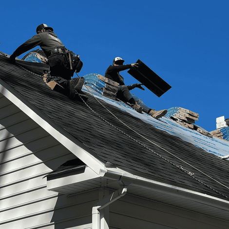 Two men are working on the roof of a house
