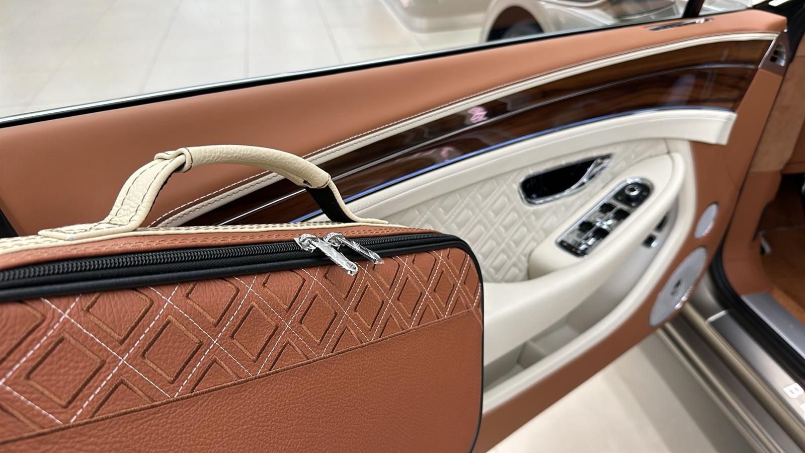 Een bruine tas ligt in de deur van een auto.