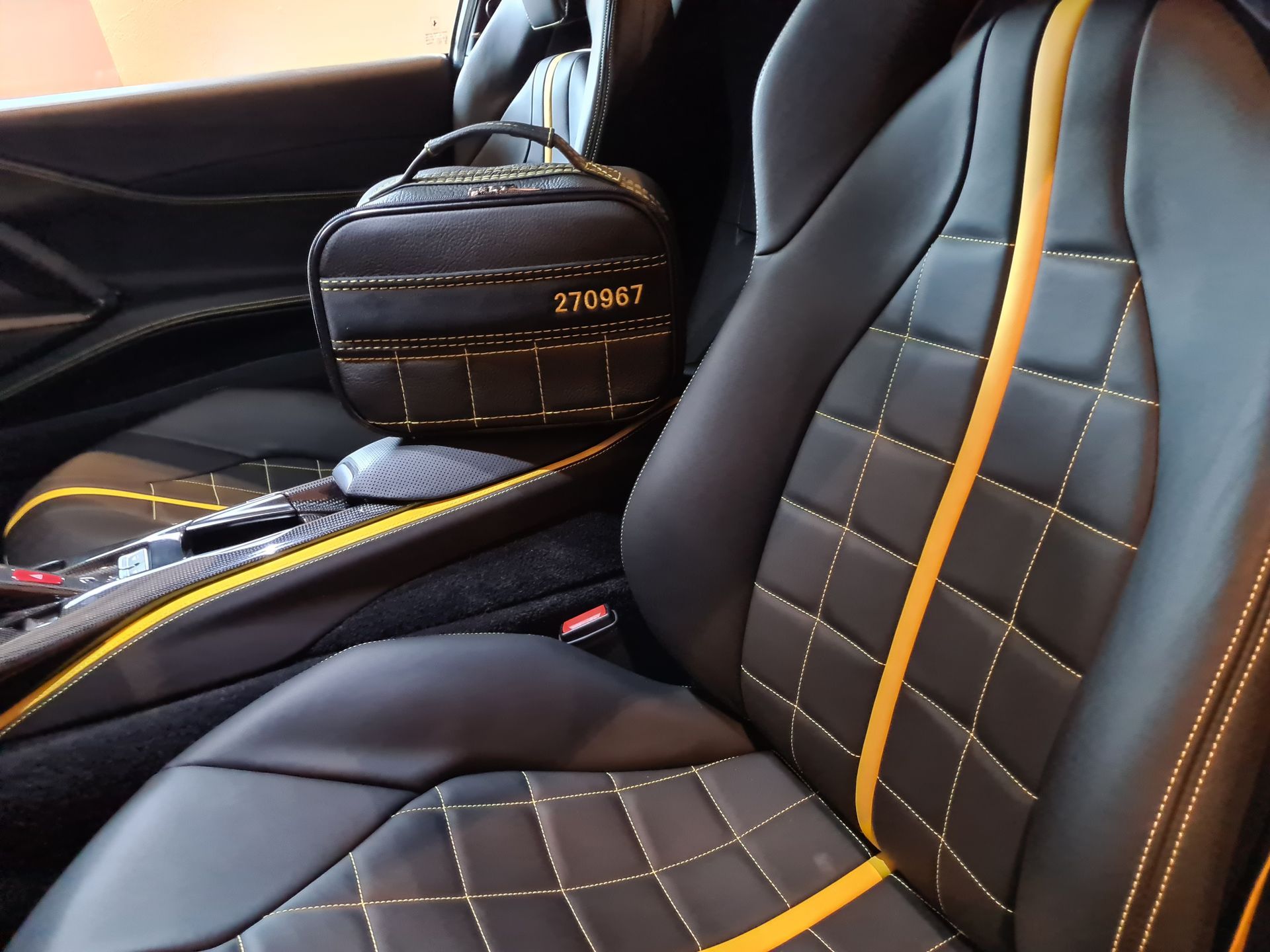 Een zwarte autostoel met een gele streep erop