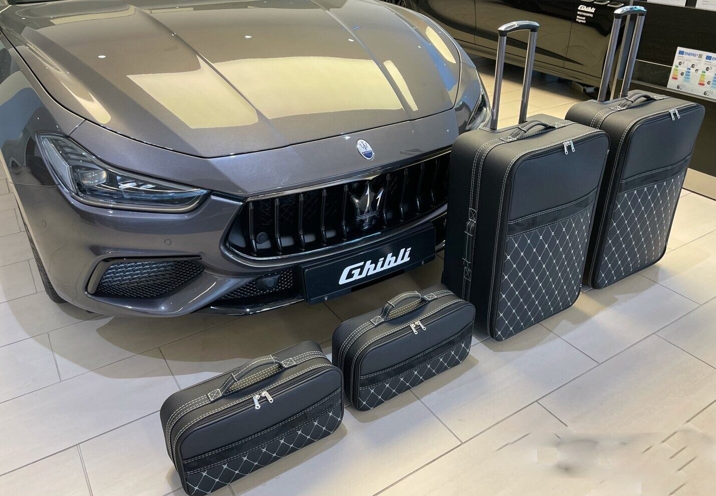 Een maserati staat geparkeerd naast een set bagage.