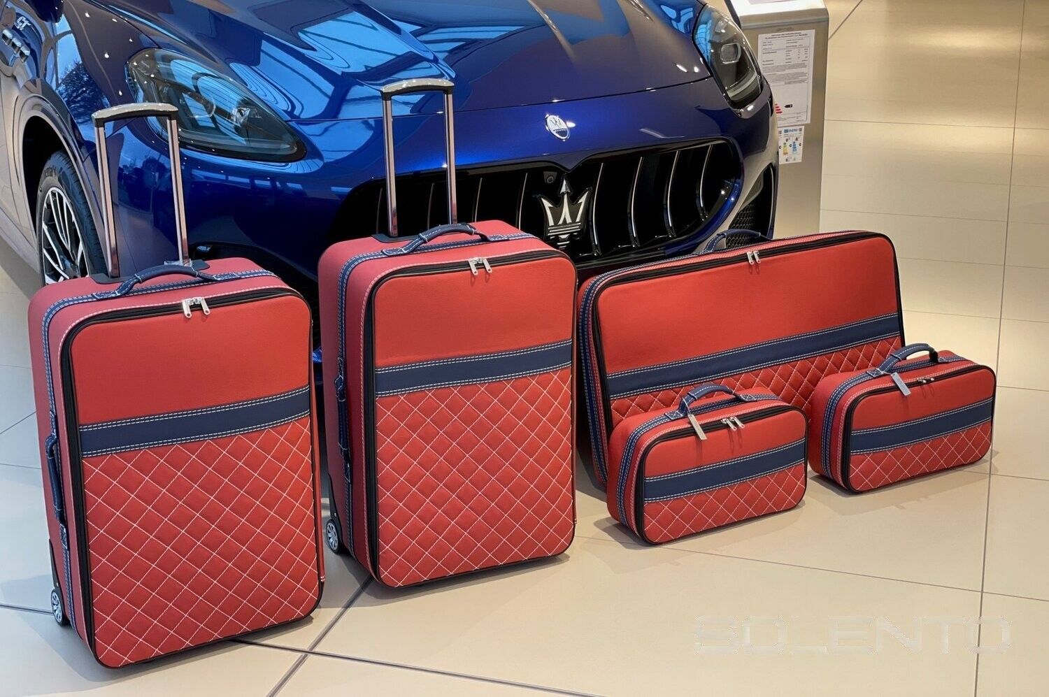 Een set rode en blauwe koffers voor een blauwe auto