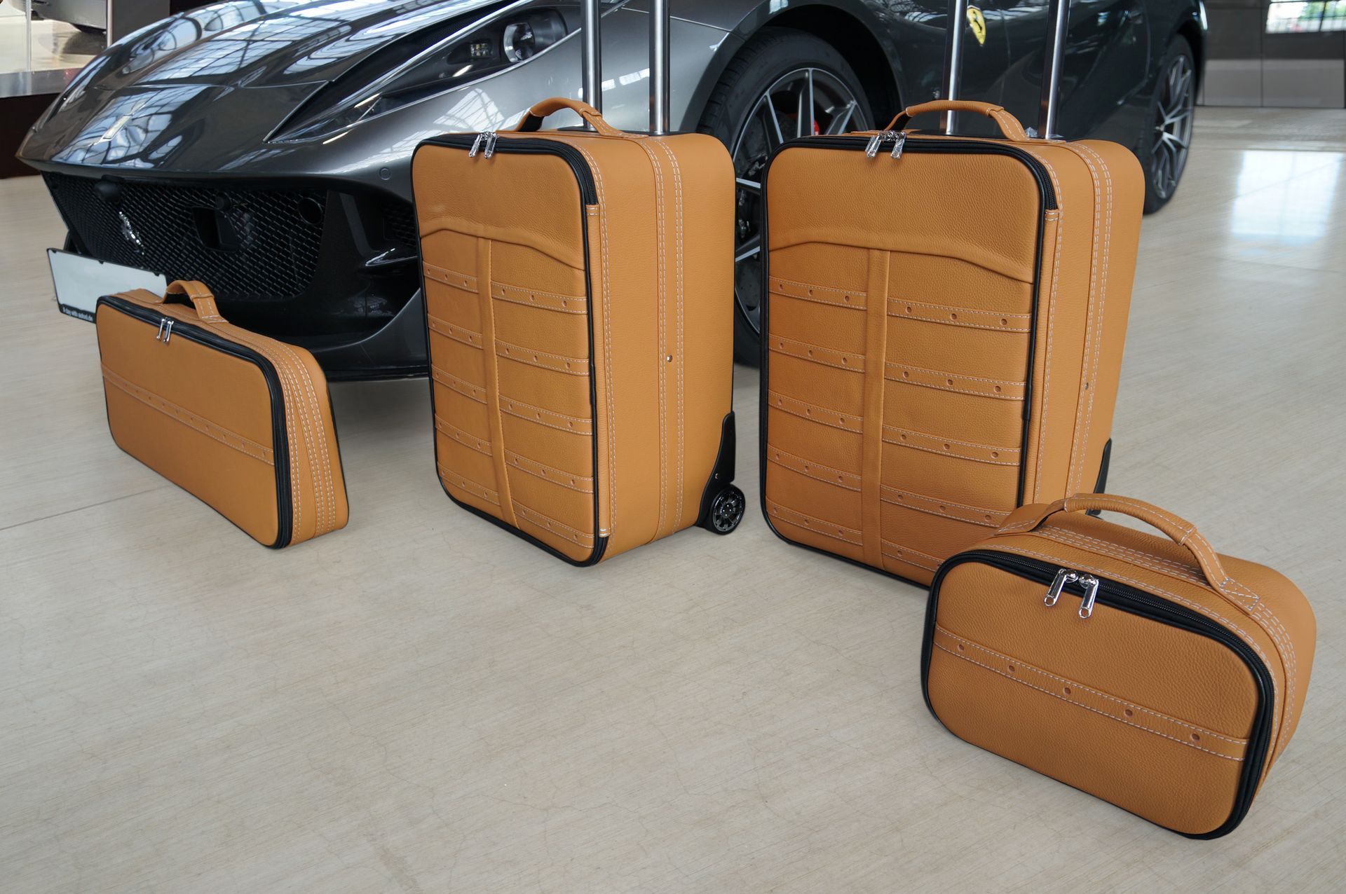 Een set bagage staat voor een Ferrari