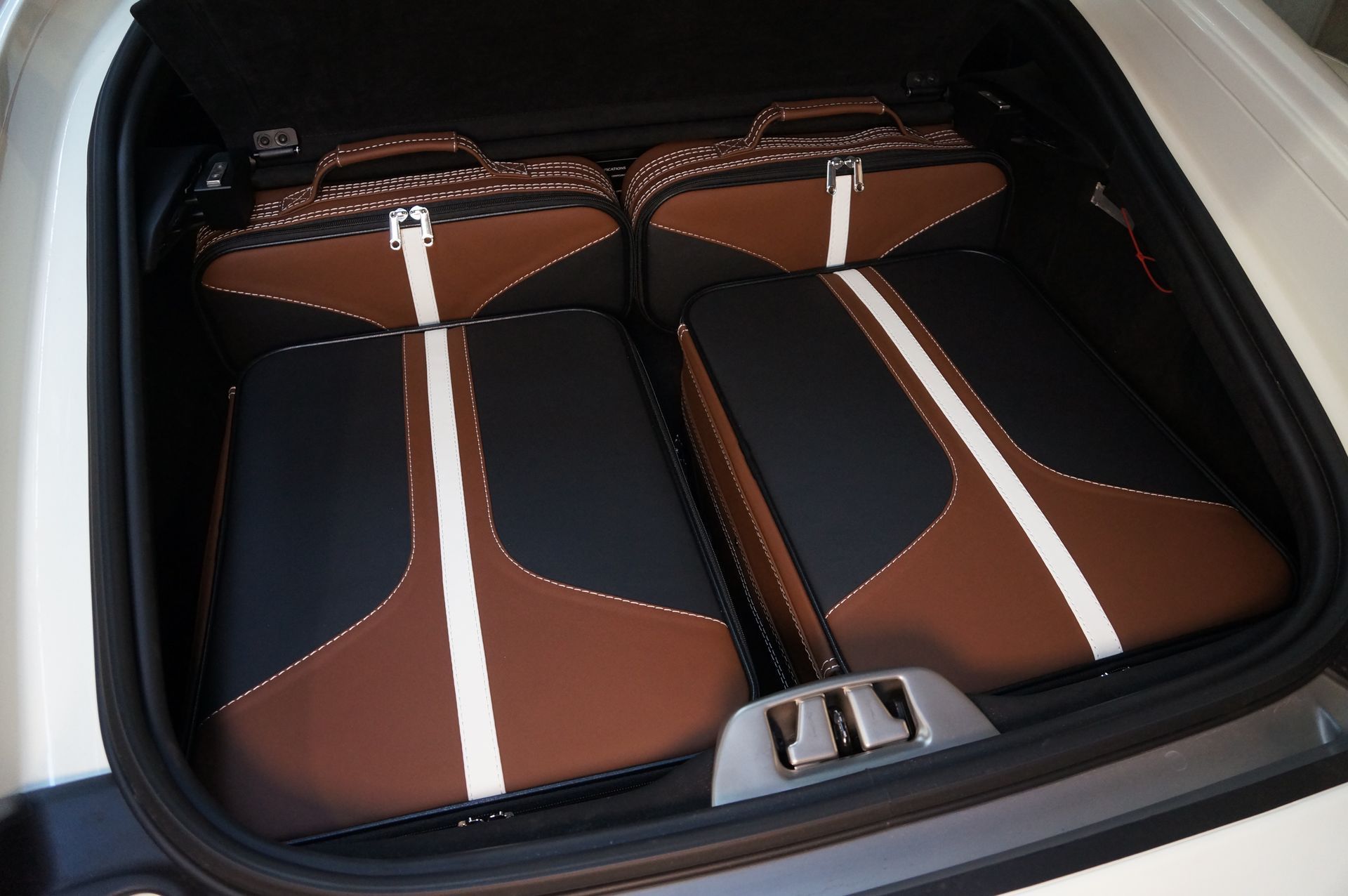 In de kofferbak van een auto staan ​​twee bruine en witte koffers