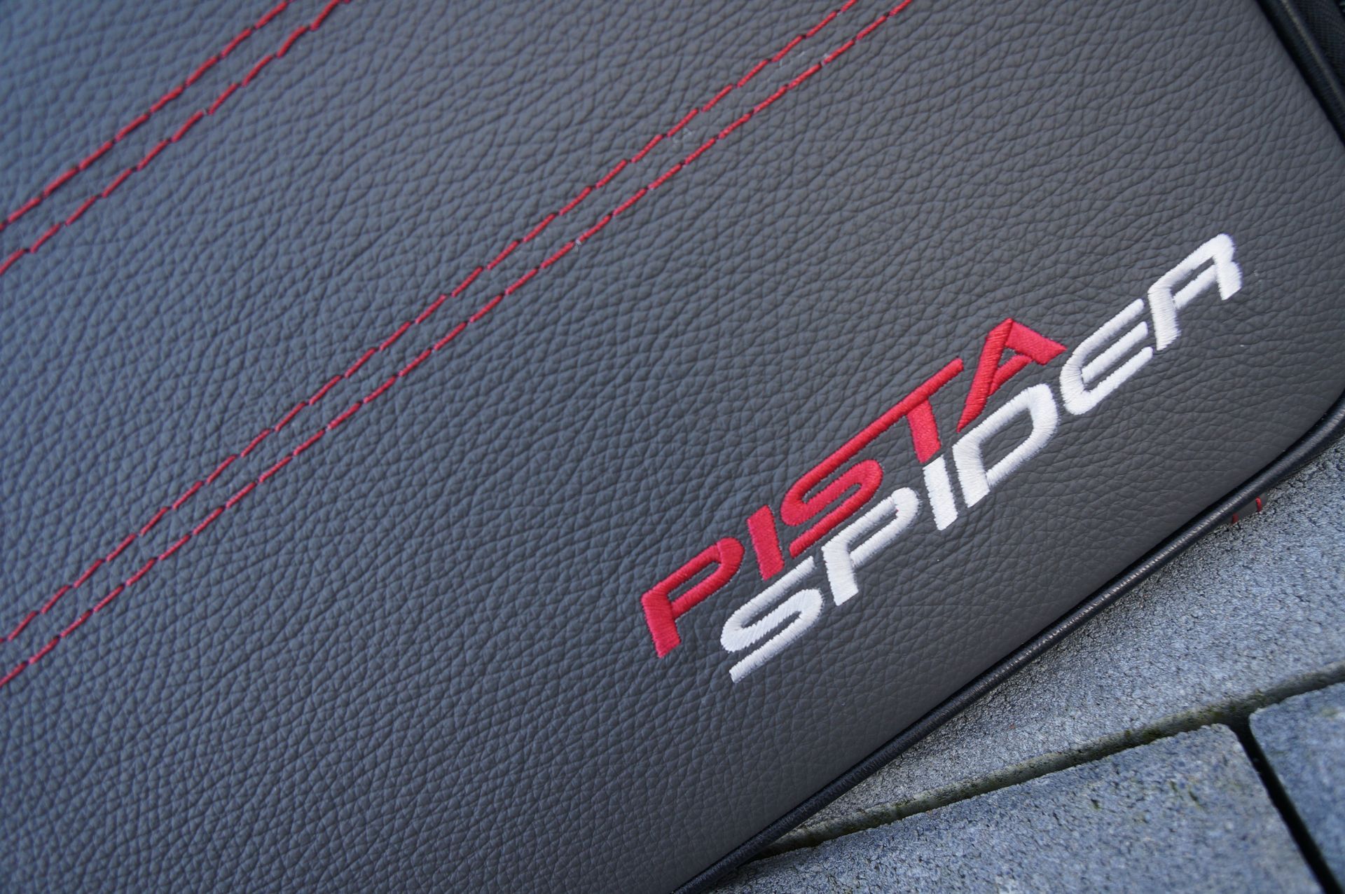 Een close-up van een zwart leren hoesje met het woord 'spin' erop.