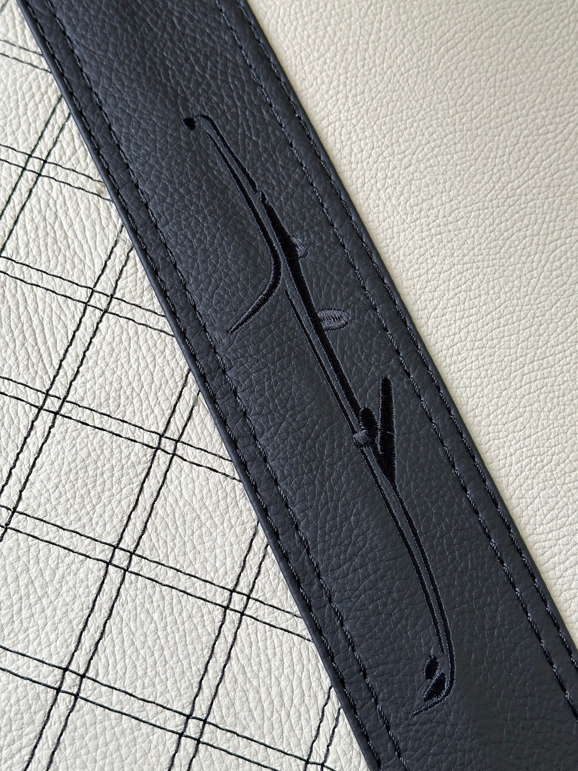 Een close-up van een zwart-witte leren riem met een gat erin.