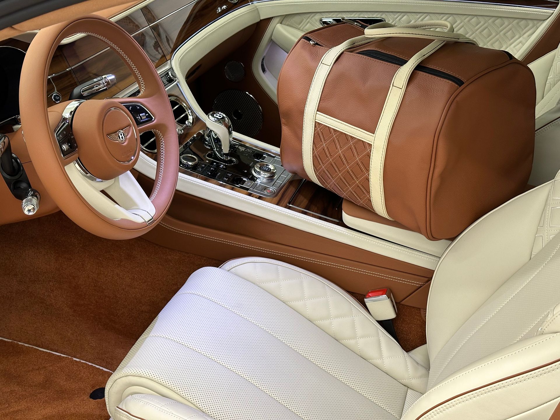 Het interieur van een auto met een bruine tas op de stoel