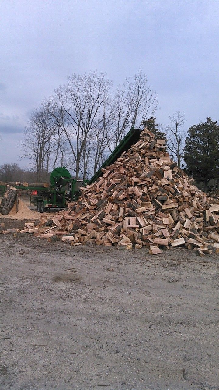 Pile of broken bricks and rubble beside a green excavator in a muddy outdoor lot under bare trees. Pile of broken bricks and rubble beside a green excavator in a muddy outdoor lot under bare trees.