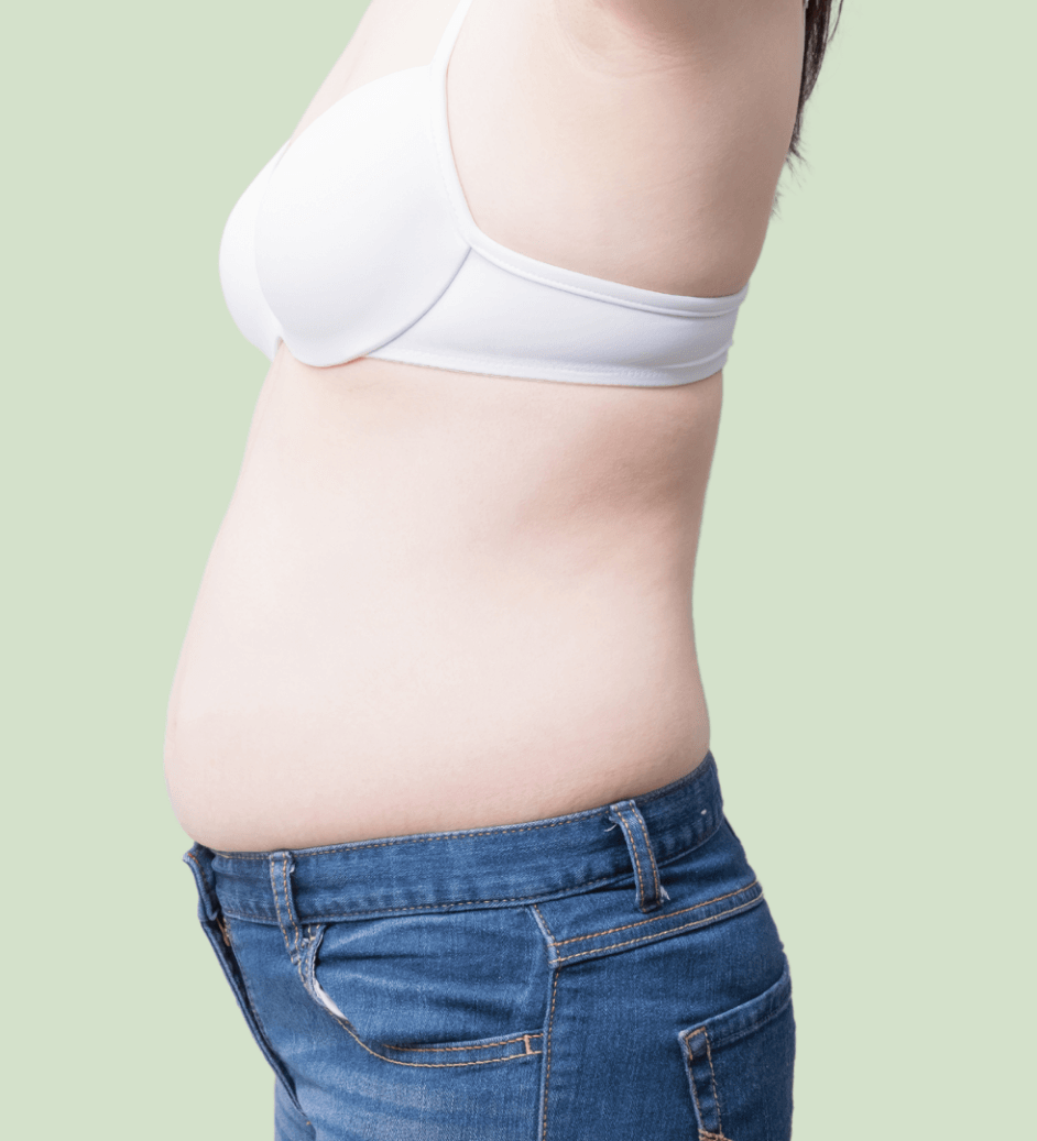 A woman is wearing a white bra and blue jeans.