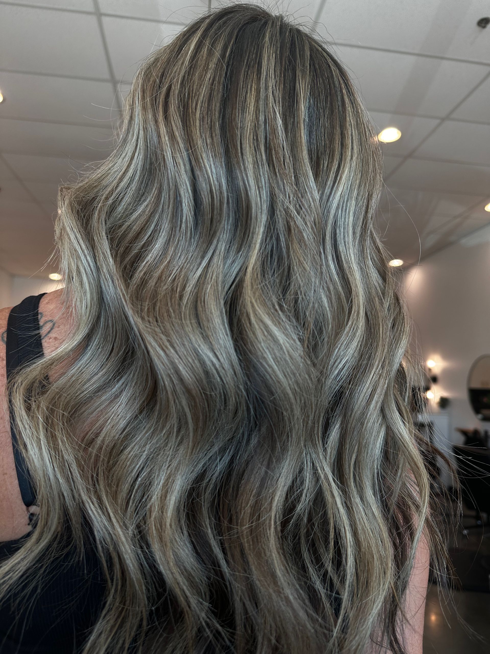 Long wavy hair with highlights of blonde and brown.
