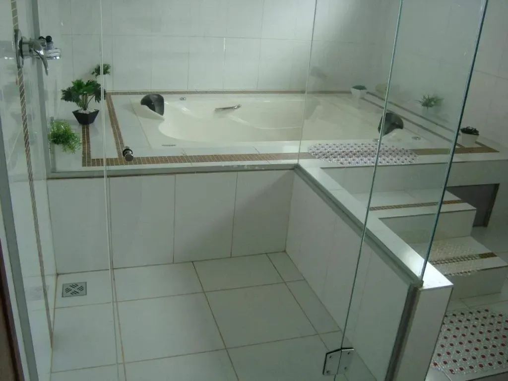 Um banheiro com banheira e chuveiro com porta de vidro-Executive-Hotel-MT