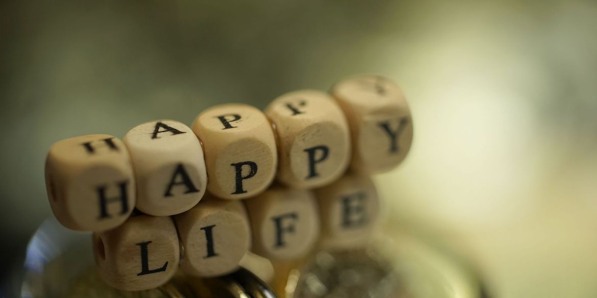 Wooden blocks spell out "HAPPY LIFE."