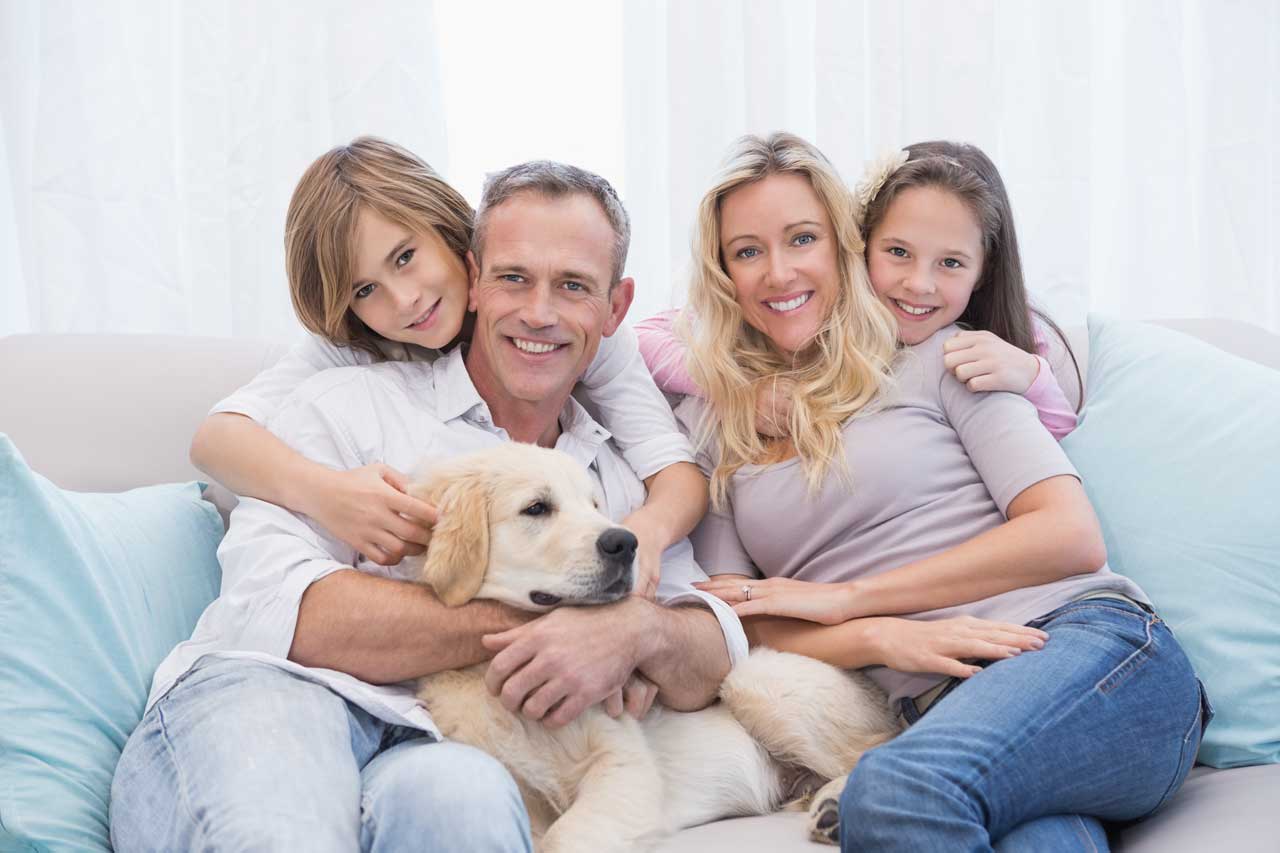 Cute-family-relaxing-together-on-the-couch-with-their-dog