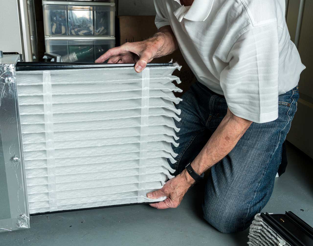 man-inserting-a-new-air-filter-in-a-HVAC-Furnace