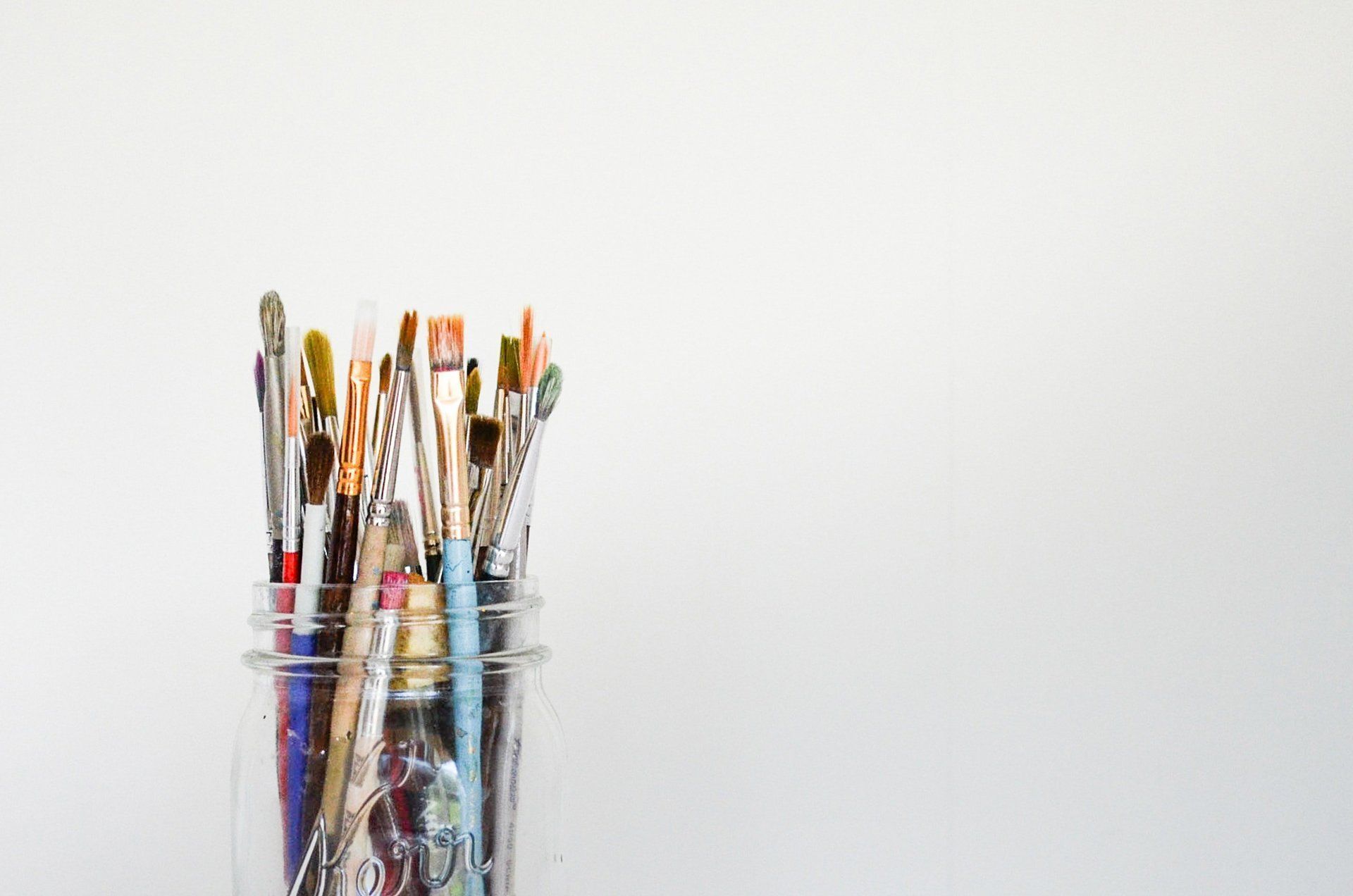 A jar filled with paintbrushes