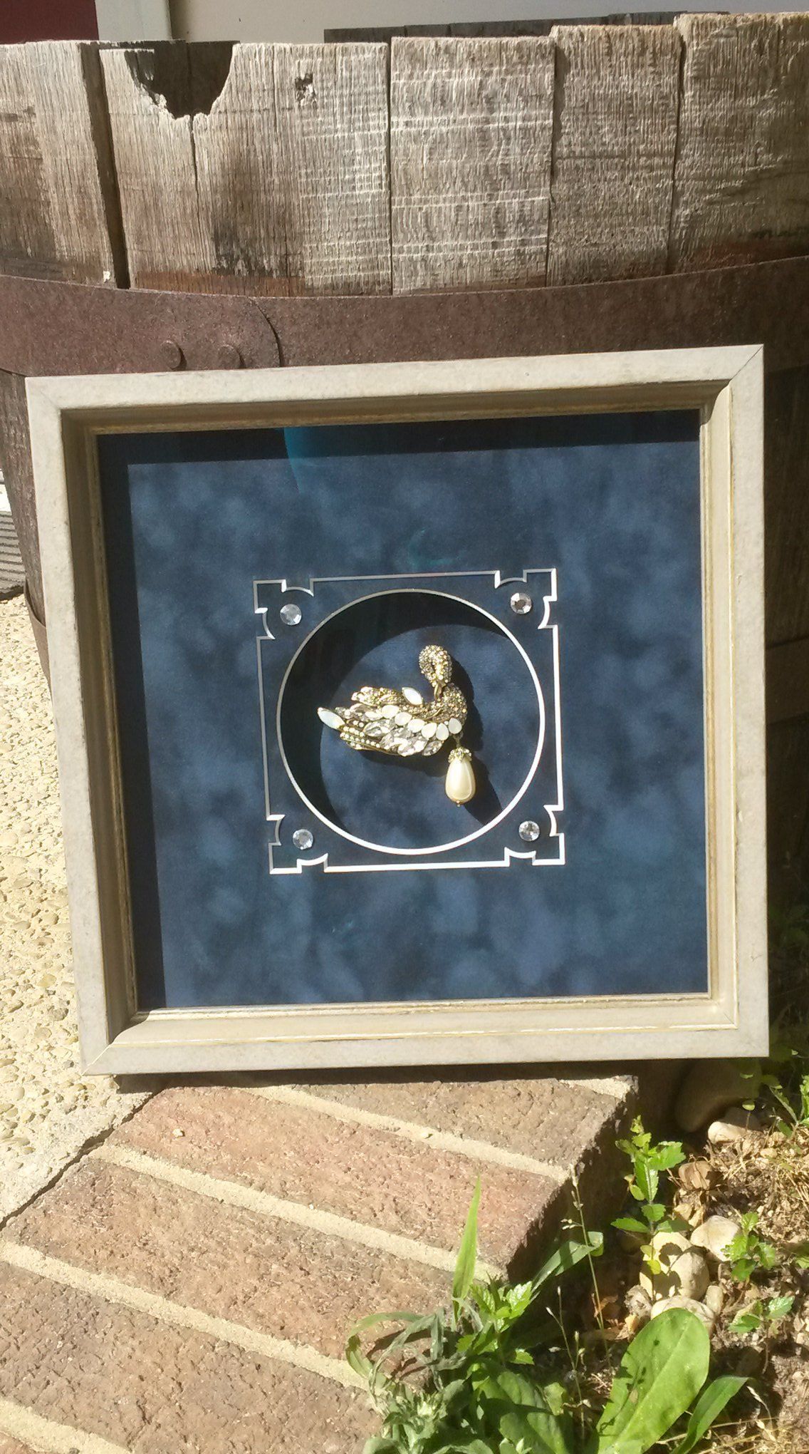 A picture of a turtle in a frame is sitting on a brick sidewalk