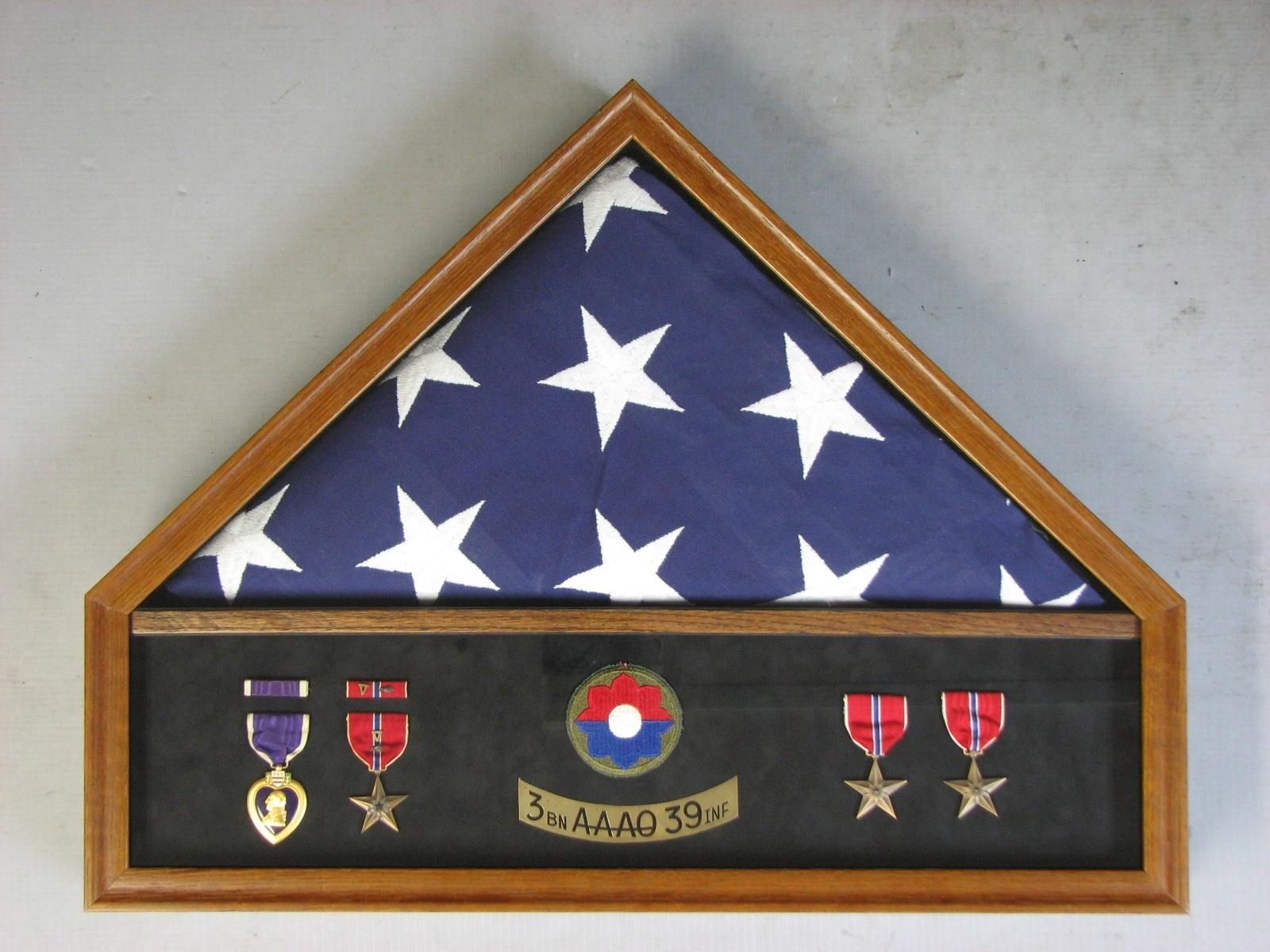 An american flag in a wooden frame with medals on it
