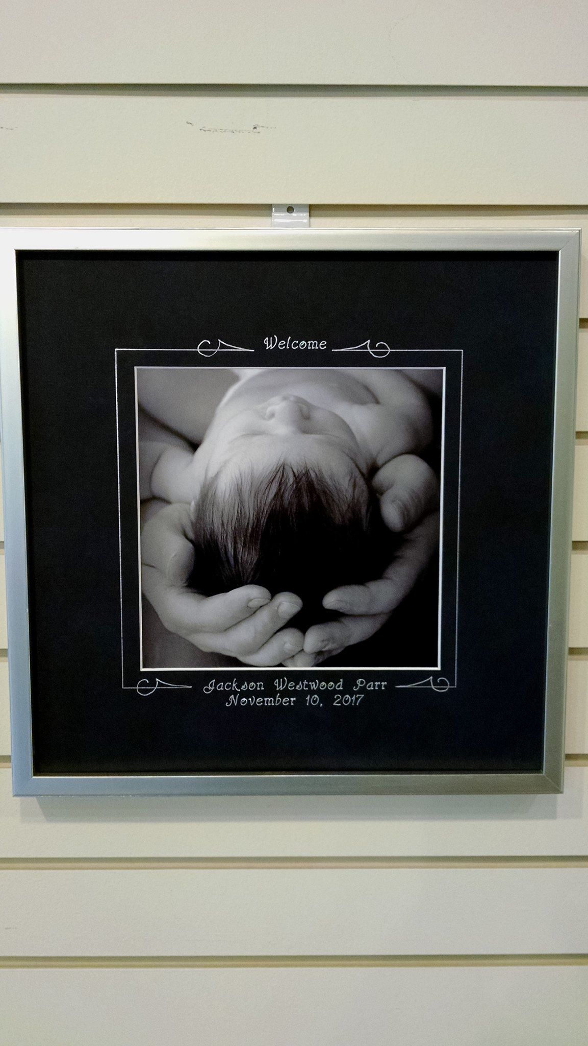 A black and white photo of a baby in a picture frame