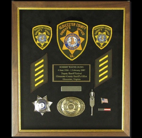 A framed display of badges from the sheriff's office