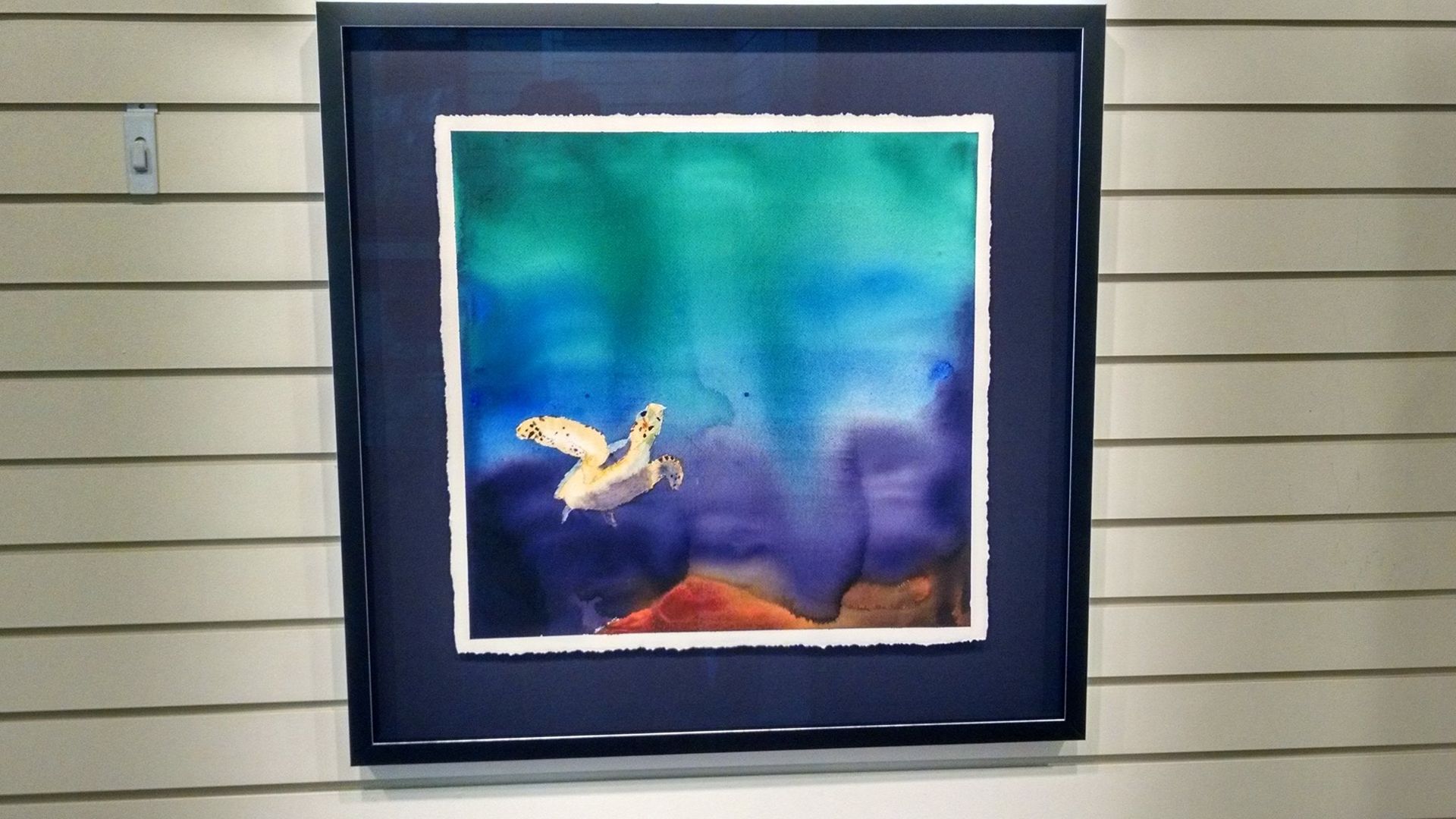 A framed painting of a bird flying in the sky