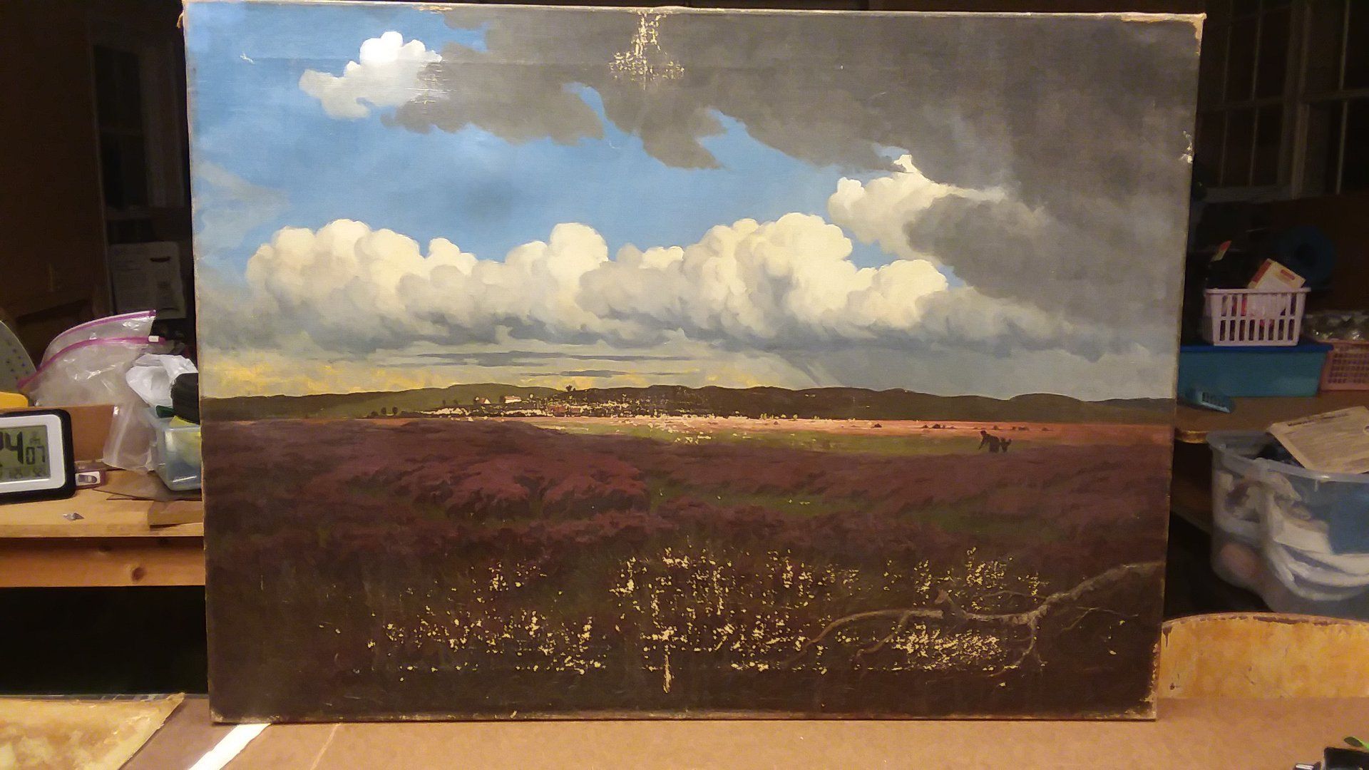 A painting of a cloudy sky is sitting on a table
