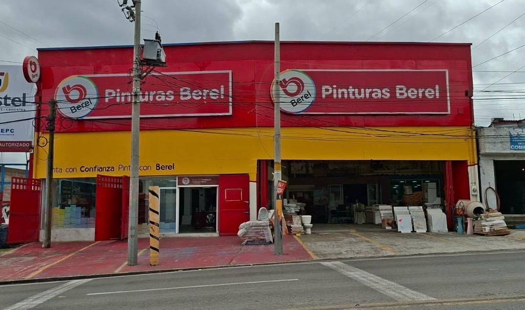 El frente de una tienda con un cartel rojo que dice pintura berel.