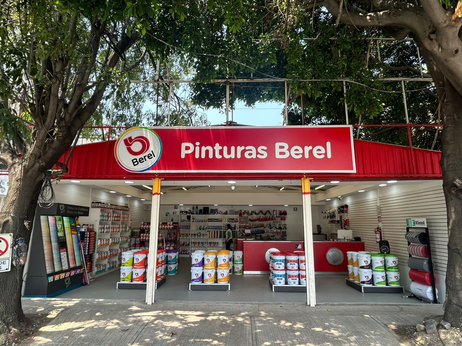 El frente de una tienda con un cartel rojo que dice pintura berel.