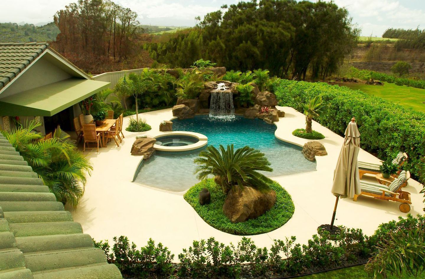 backyard pool with waterfall and hot tub in Maui