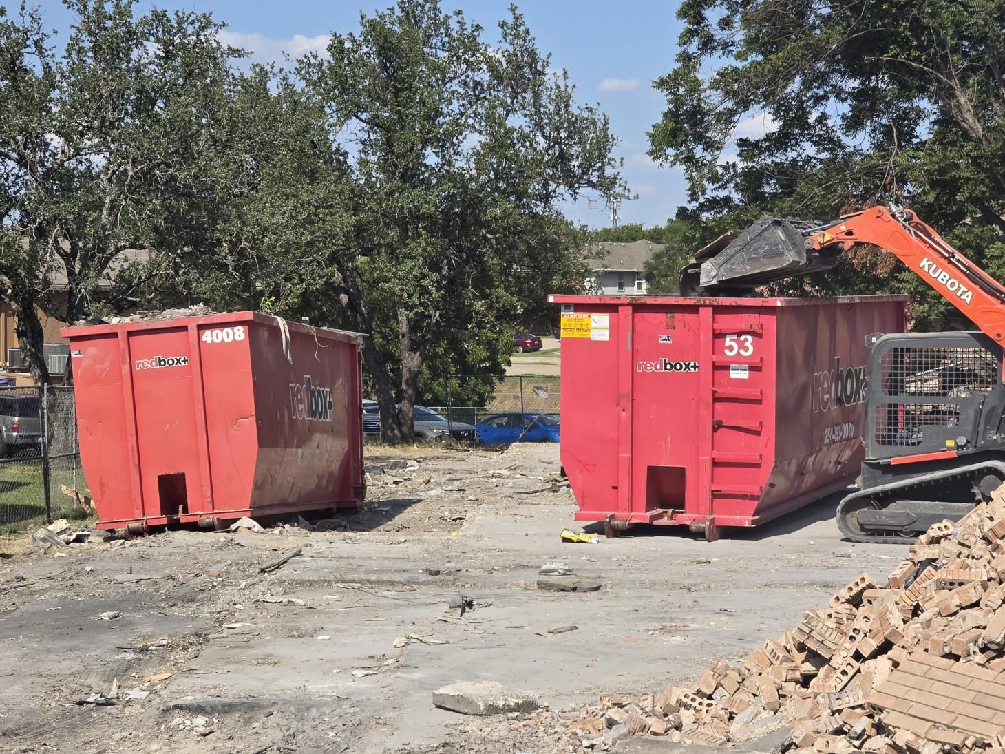 a dumpster filled with stuffed animals sits in front of a brick wall .