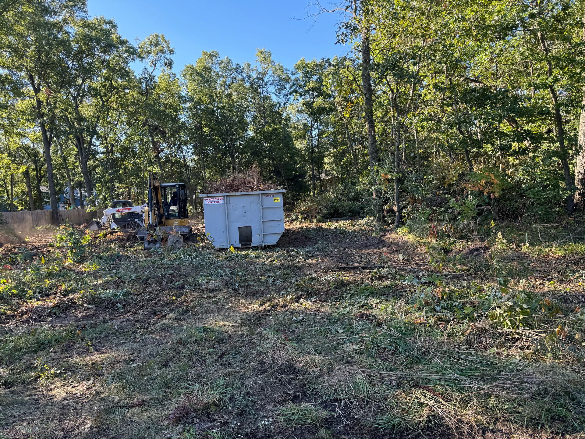 A house with a concrete driveway and a wheelbarrow in front of it.