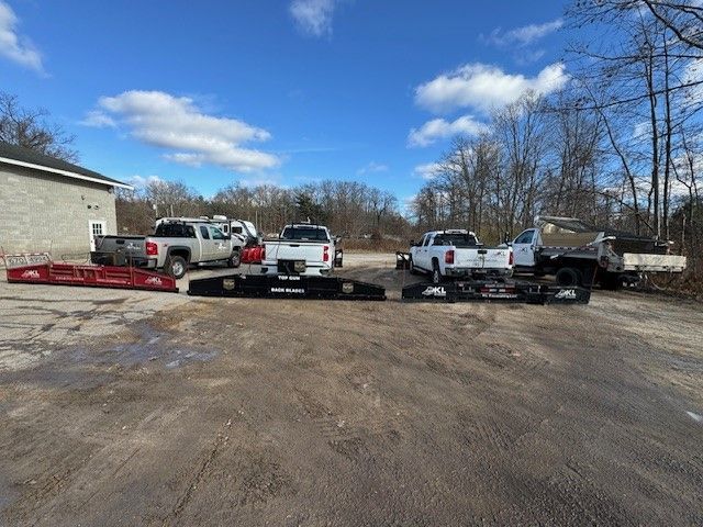 A bulldozer is loading snow into a dump truck.